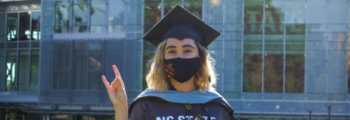 Graduate in a mask on NC State campus.