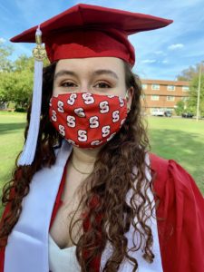 Ashley Ramos in graduation attire and a mask.