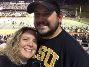 Photo of Suzanne Edmonds and her husband at an Appalachian State football game