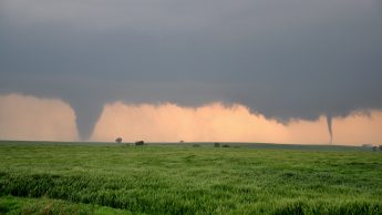 Tornadoes pictured in the distance of a field. Photo from Postdoctoral Research Scholar Brice Coffer.