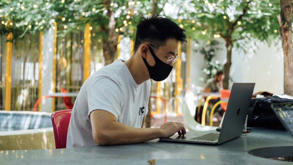 man with mask on computer