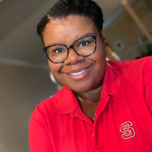 Jamie Pearson smiles for a headshot in an NC State polo shirt. 
