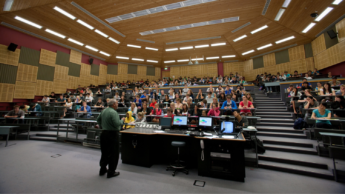 Professor faces a full lecture hall.