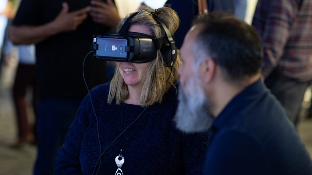 person using VR headset while DELTA staff member discusses