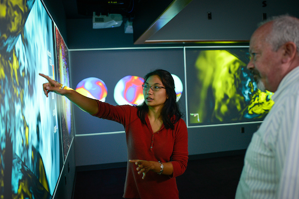 Math professor in a multimedia lab pointing at a screen.